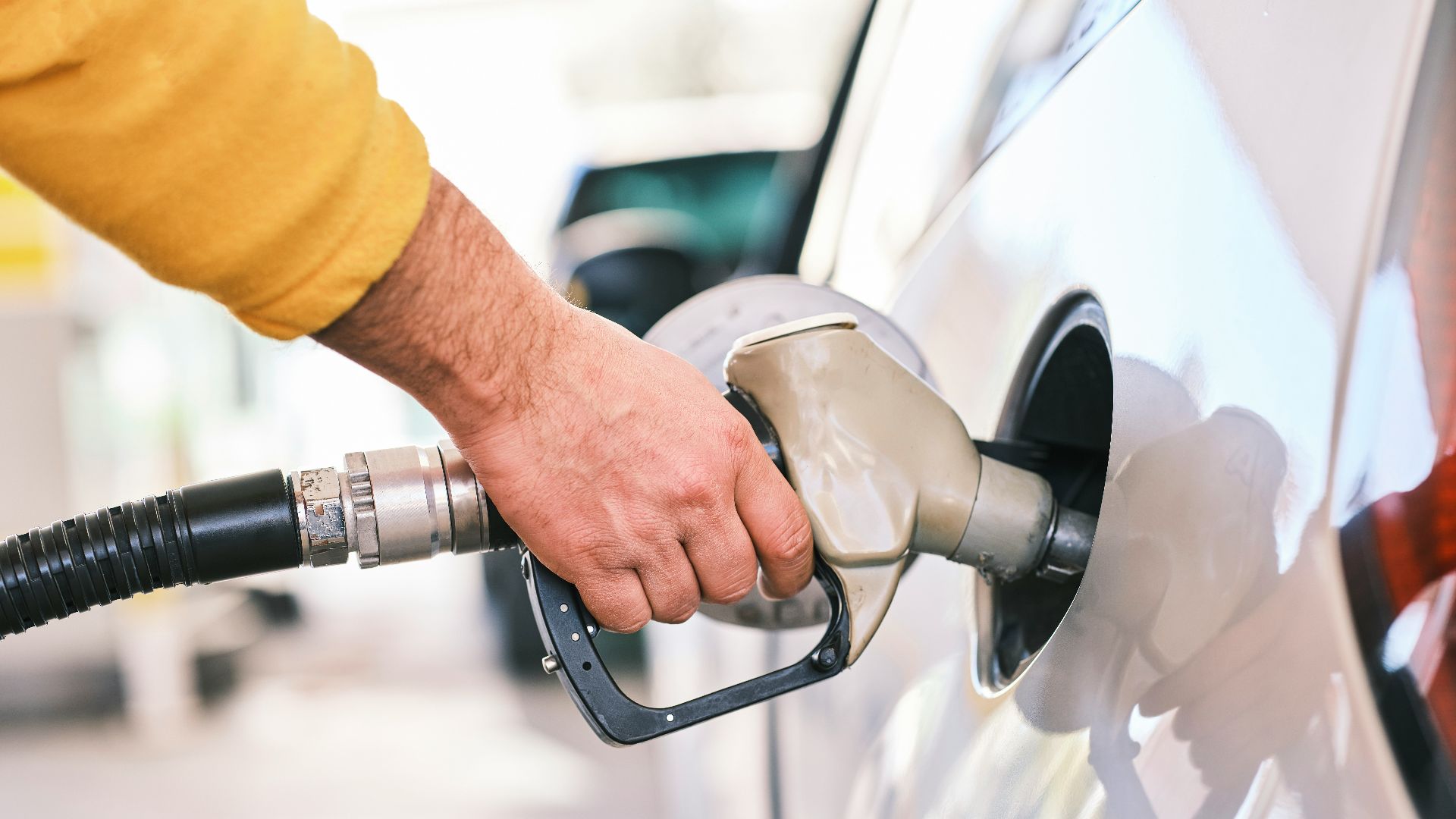 a man pumping gas into his car at a gas station