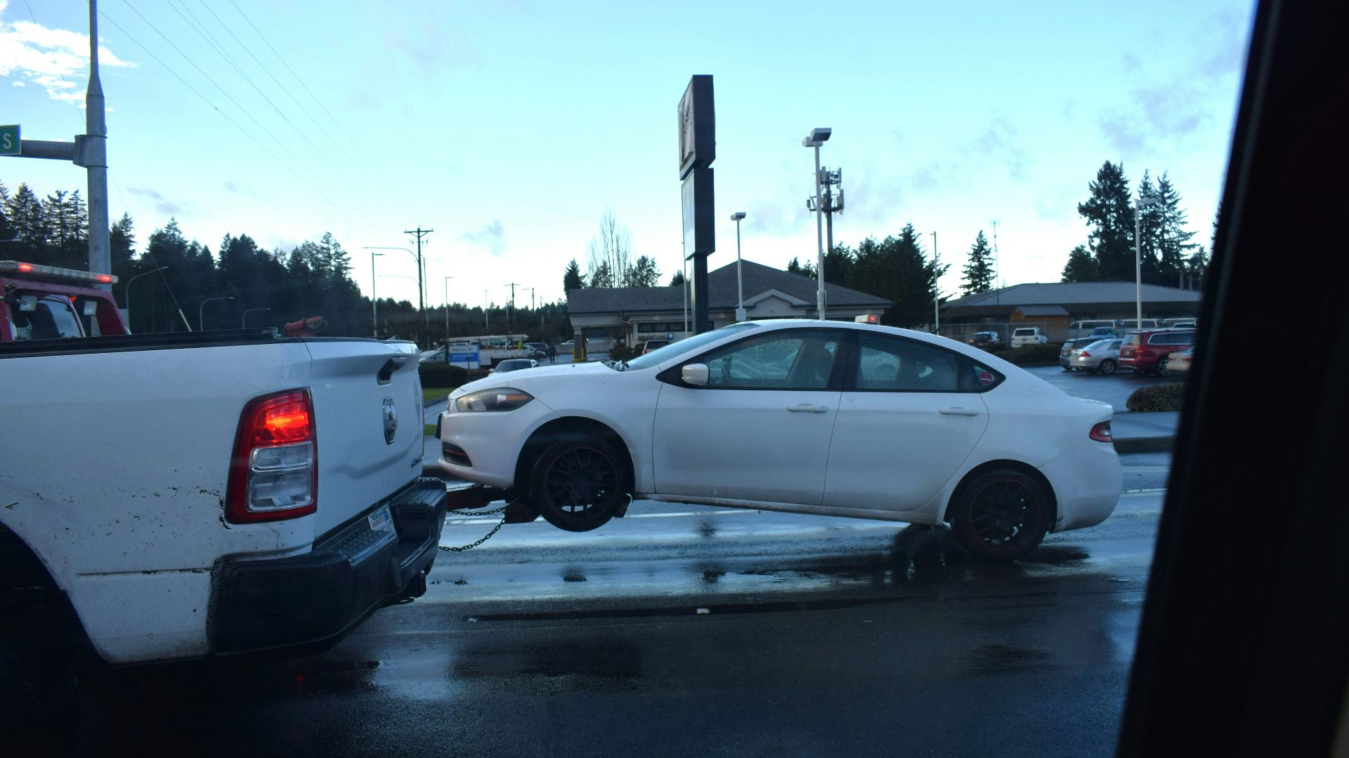 a white car being towed by a tow truck