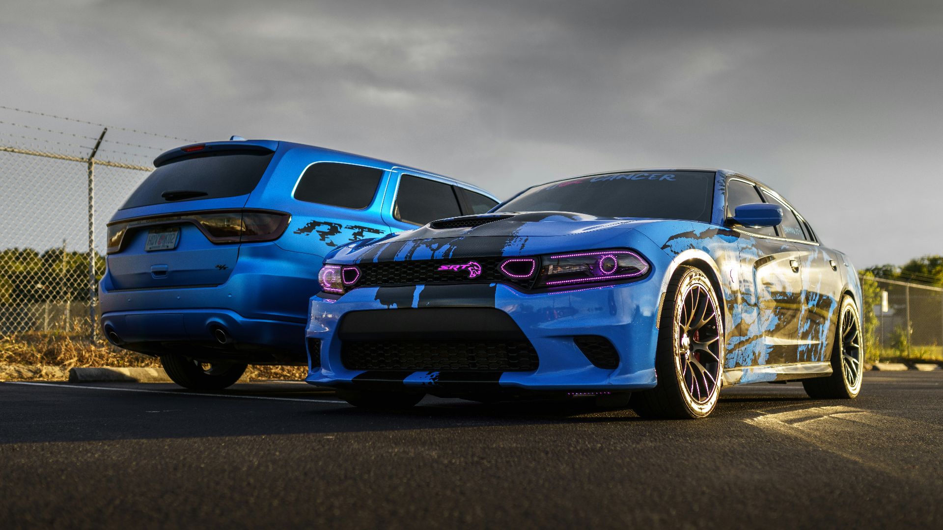 a couple of cars parked next to each other on a road