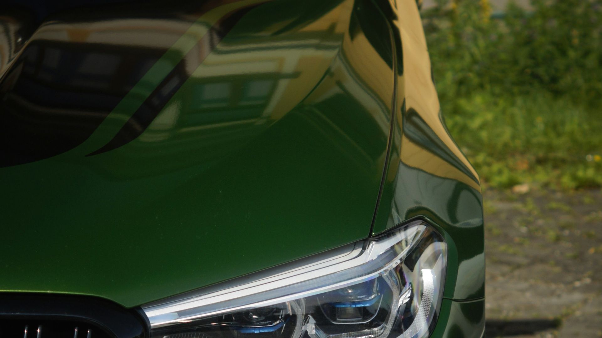 A close up of a green car parked on a street