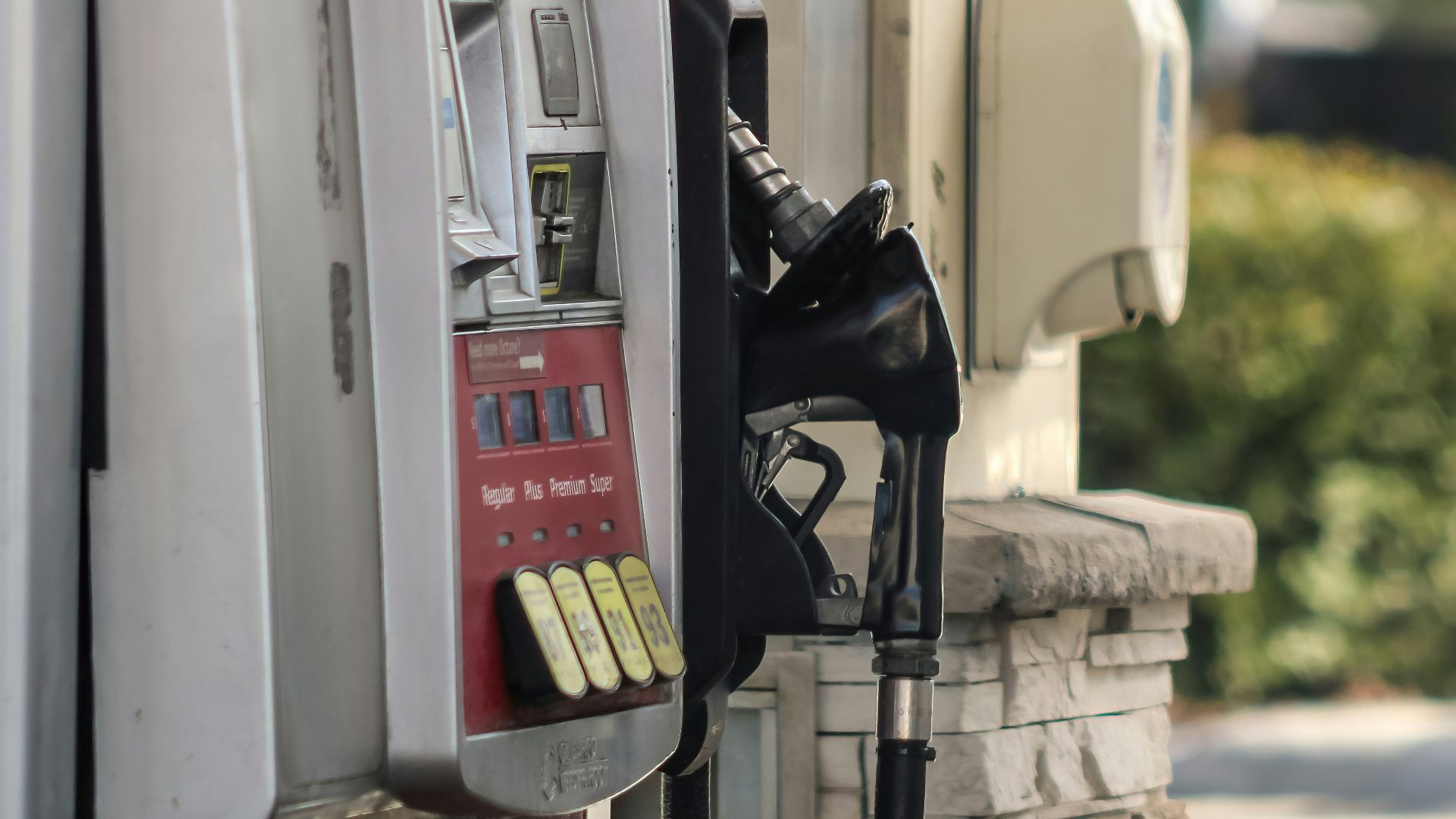 a gas pump next to a brick wall