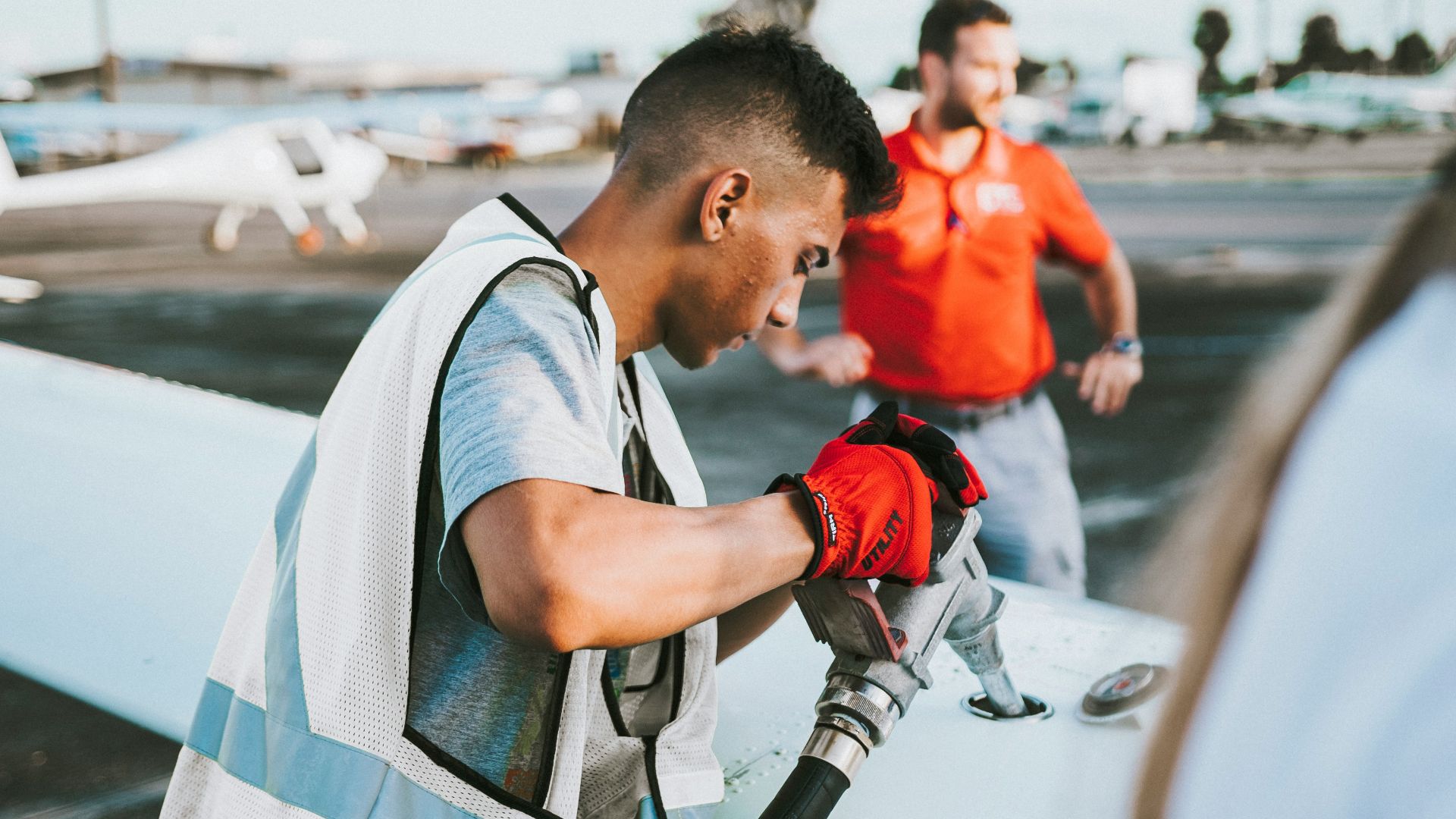 man fueling plane near man