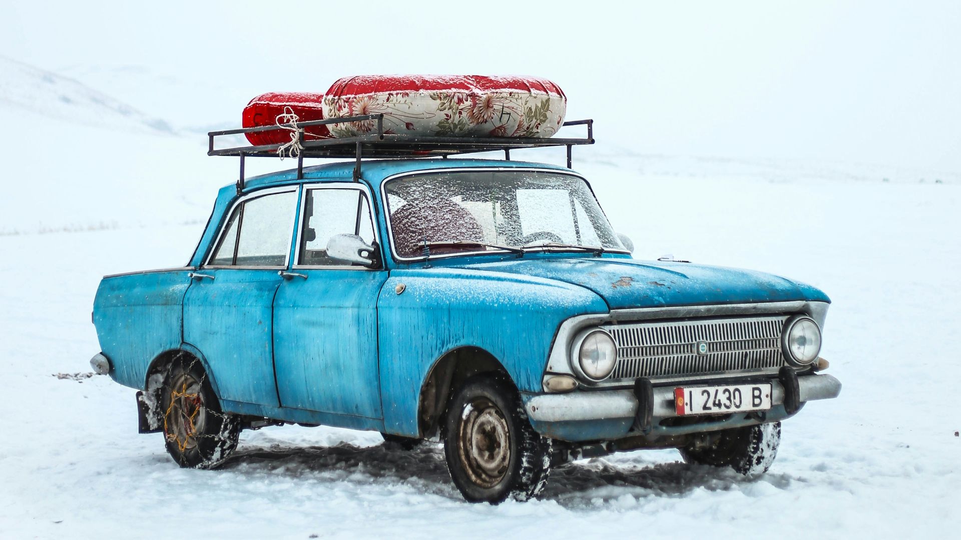 blue sedan on snow ground
