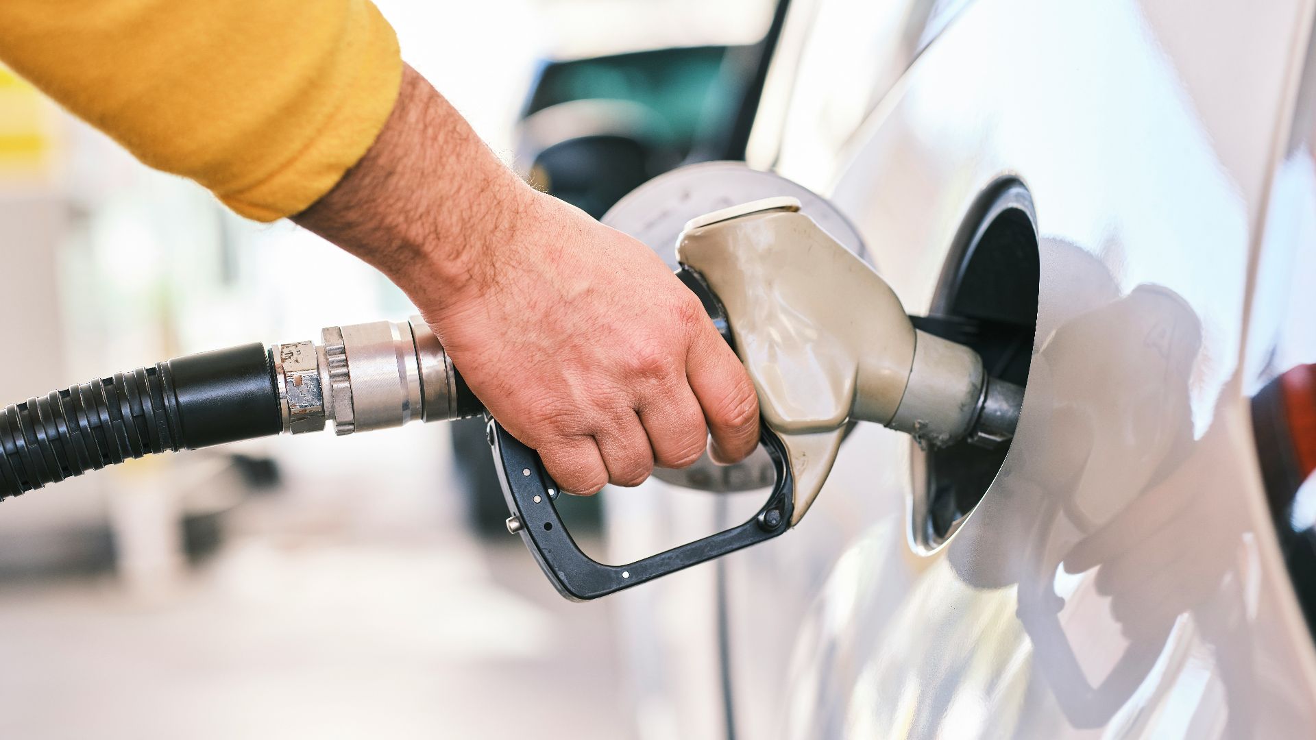 a man pumping gas into his car at a gas station