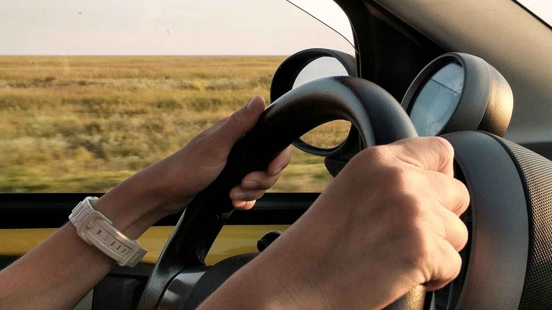 person with white watch driving car