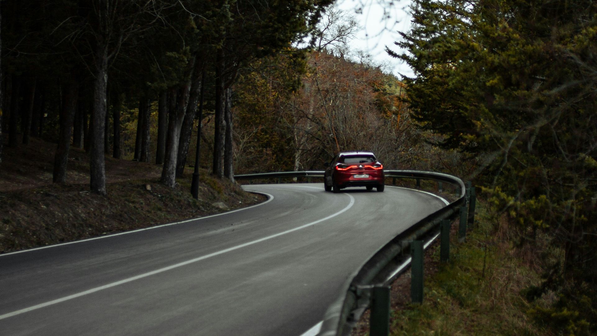 a red car driving down a curvy road