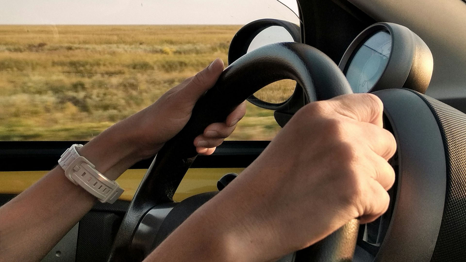 person with white watch driving car