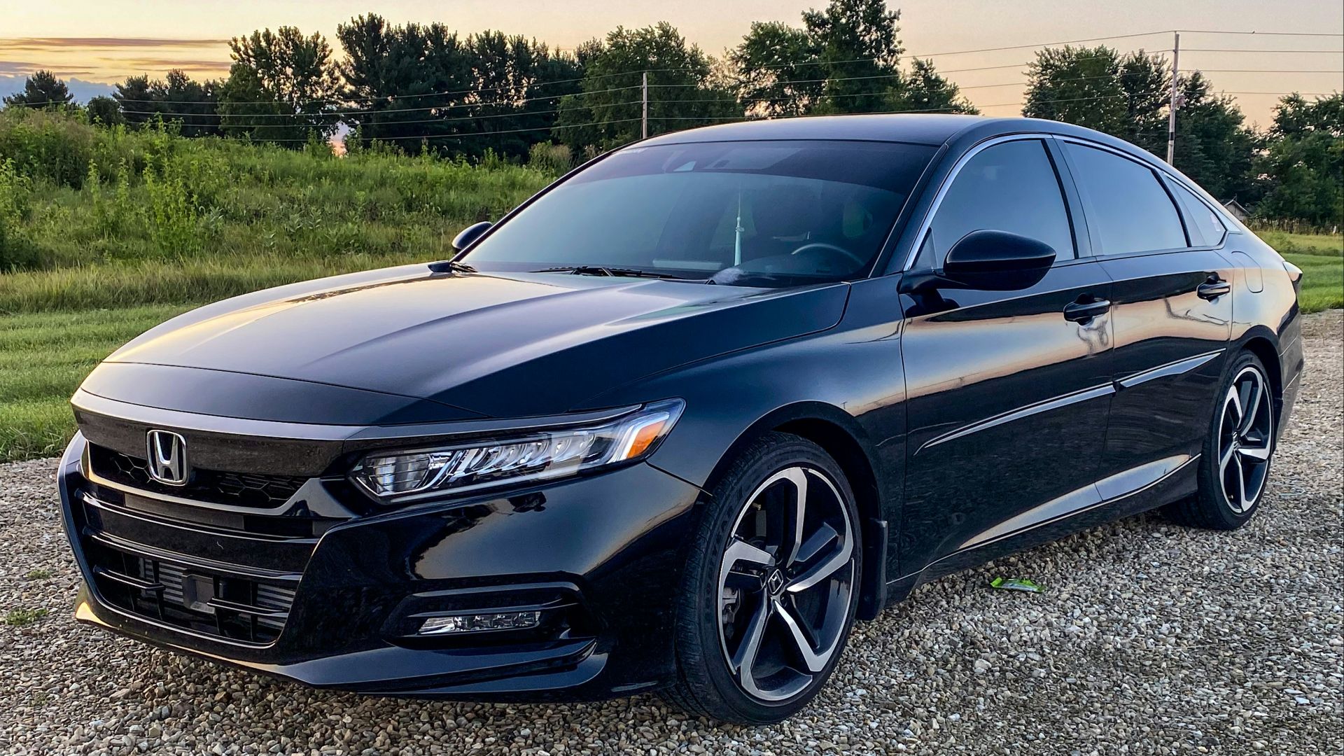 a black car parked on a gravel road
