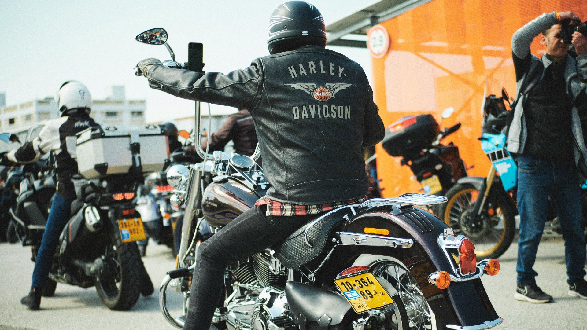 a man sitting on a motorcycle in a parking lot