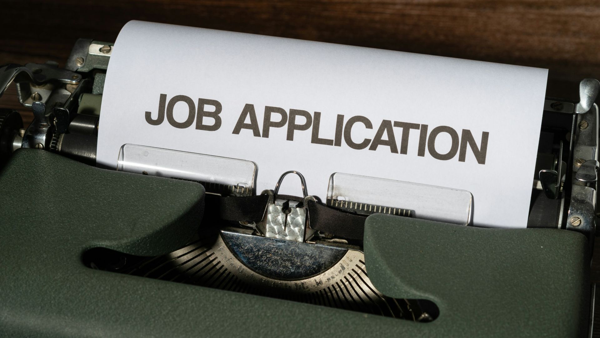 a typewriter with a job application printed on it