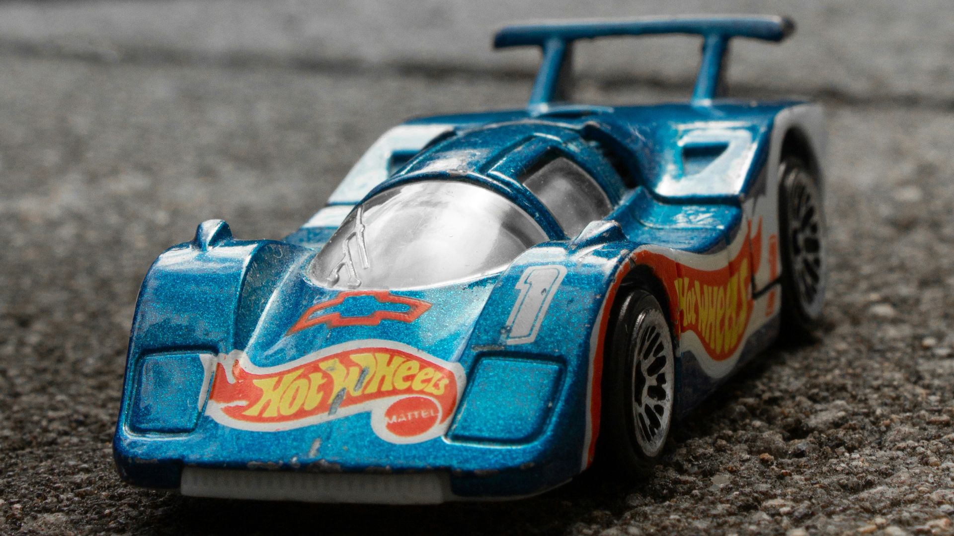 a blue toy car sitting on top of a street