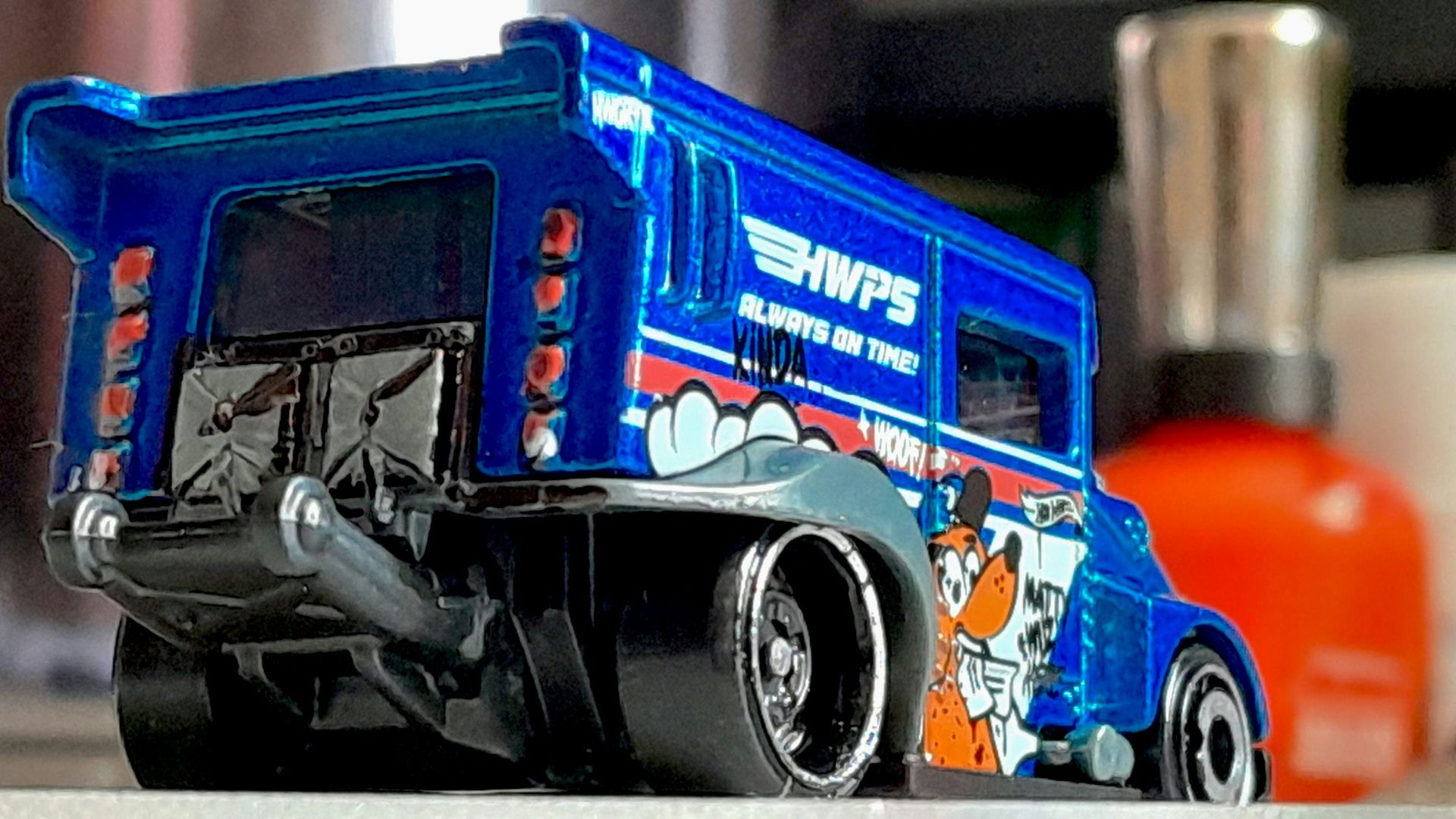 A blue toy van with cartoon graphics.