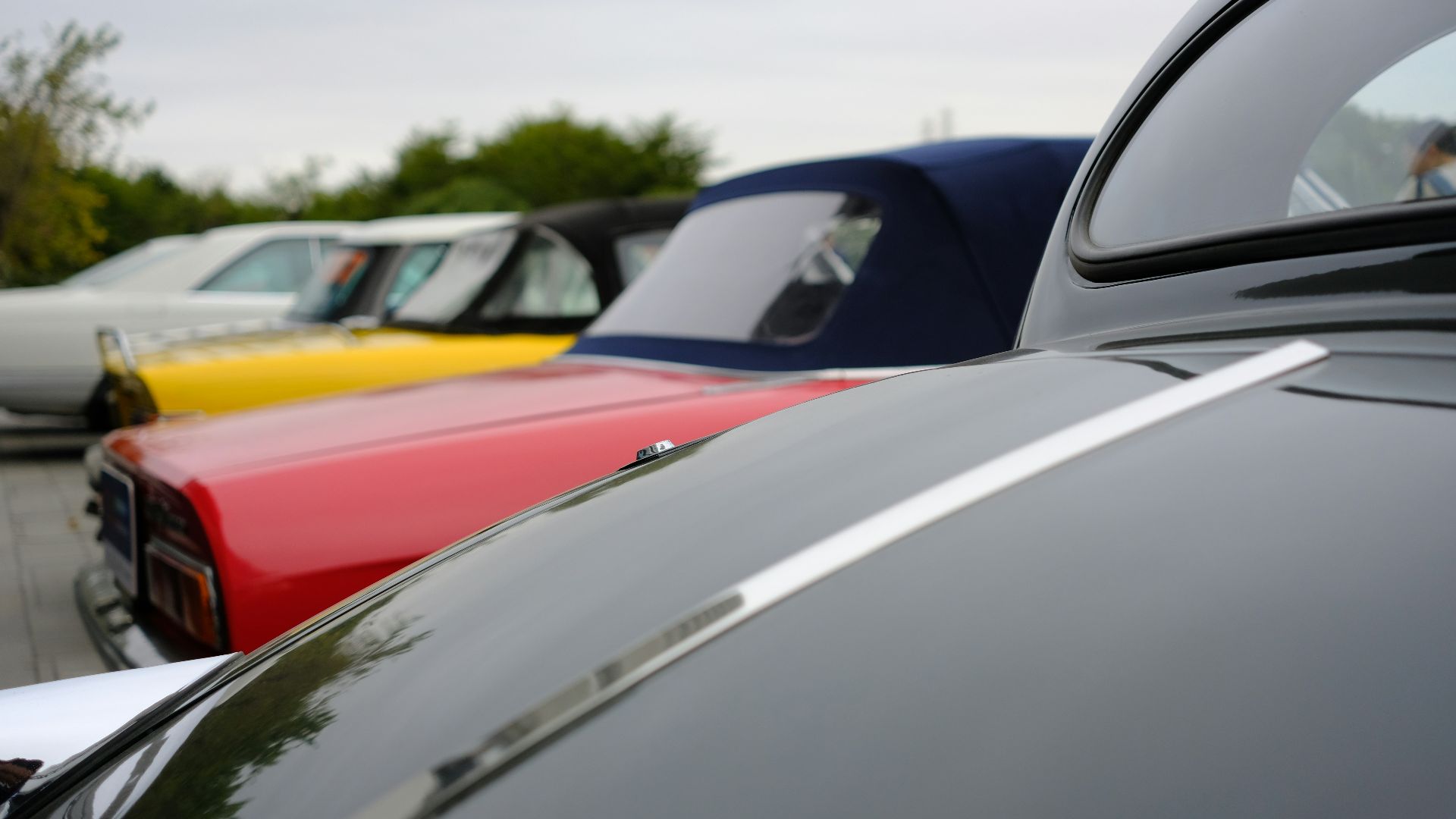 Row of vintage cars with colorful hoods