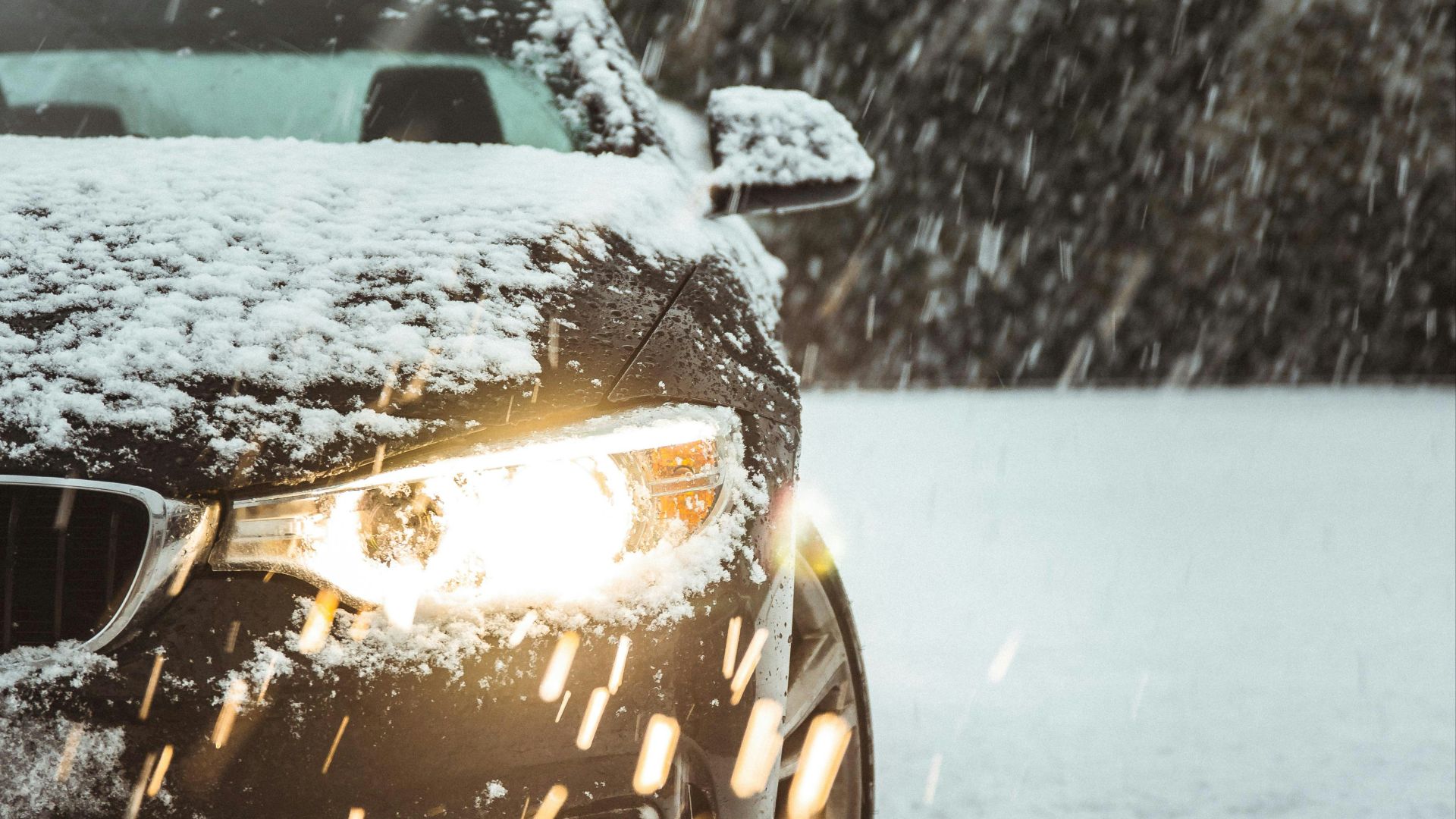 black car on snow covered road during daytime