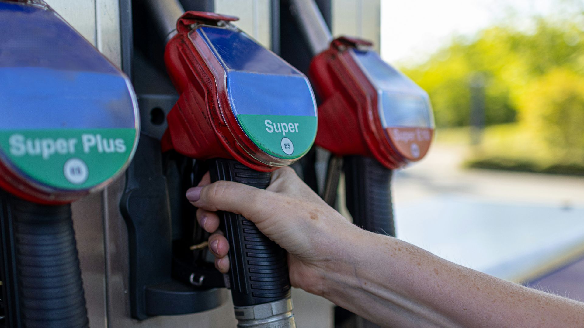 a person's hand is holding a gas pump