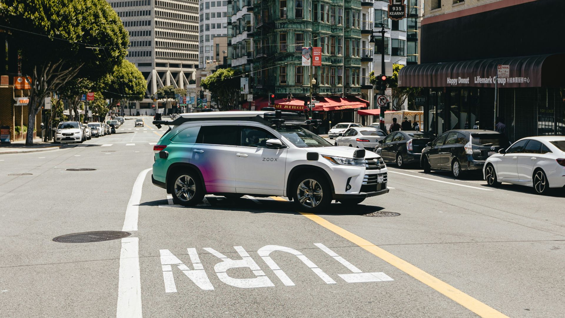 a car driving down a street next to tall buildings