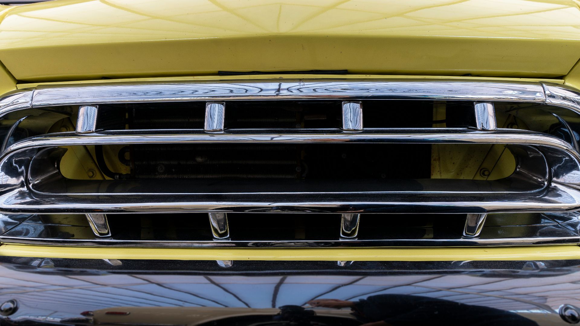 a close up of the front grill of a yellow truck