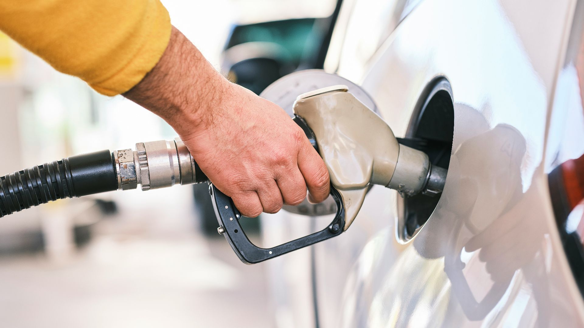a man pumping gas into his car at a gas station