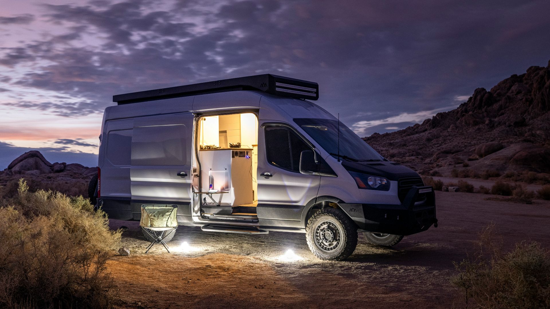white and blue suv on brown field under gray clouds