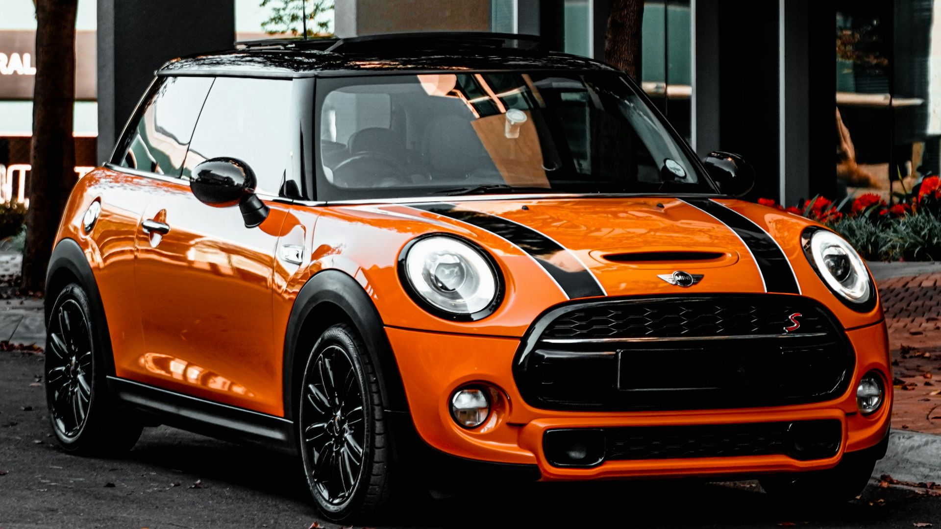 orange bmw m 3 parked on sidewalk during daytime