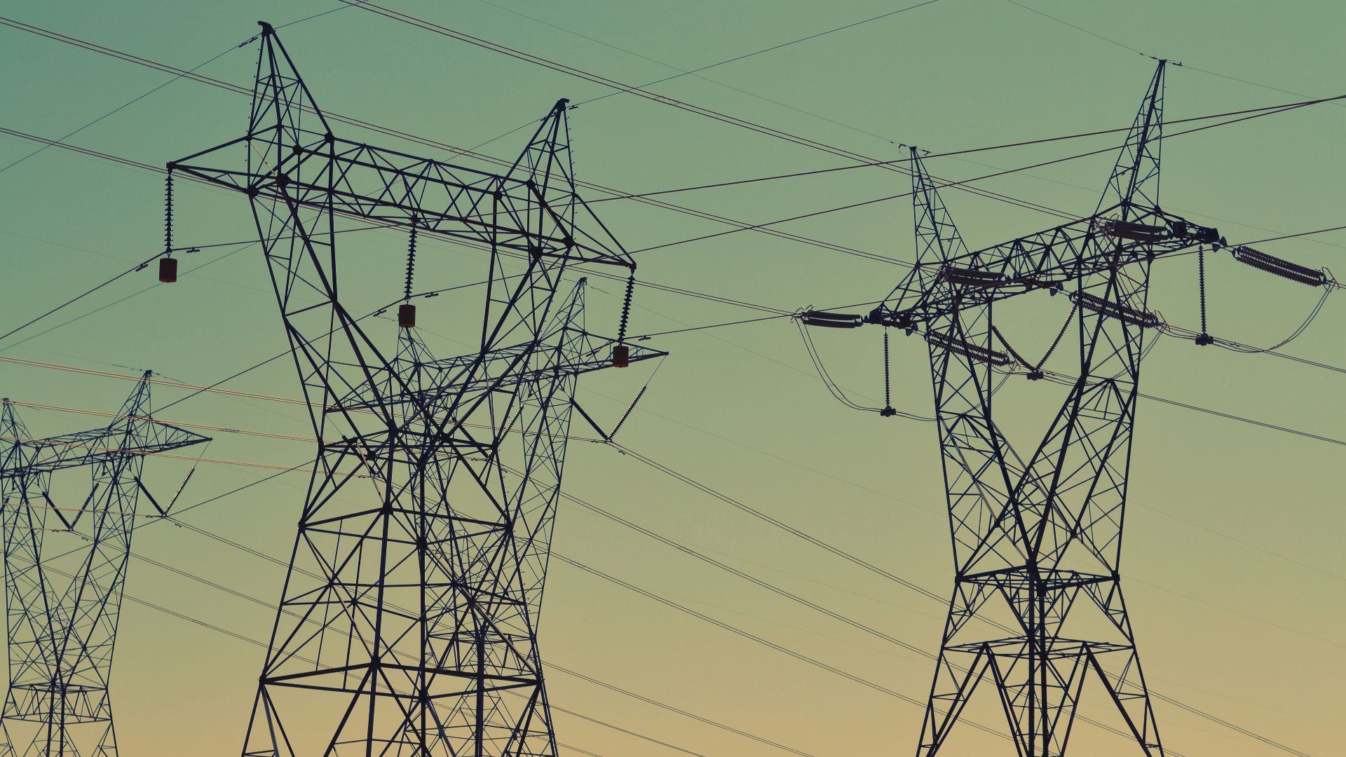 black transmission towers under green sky