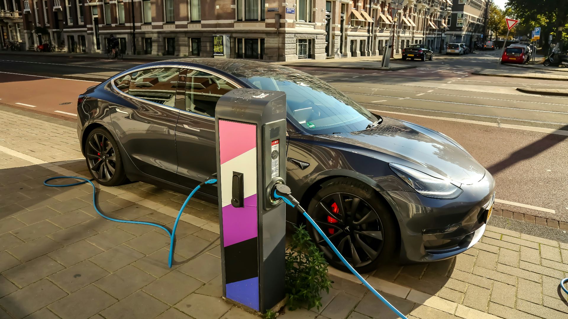 a car plugged into a charging station on a city street