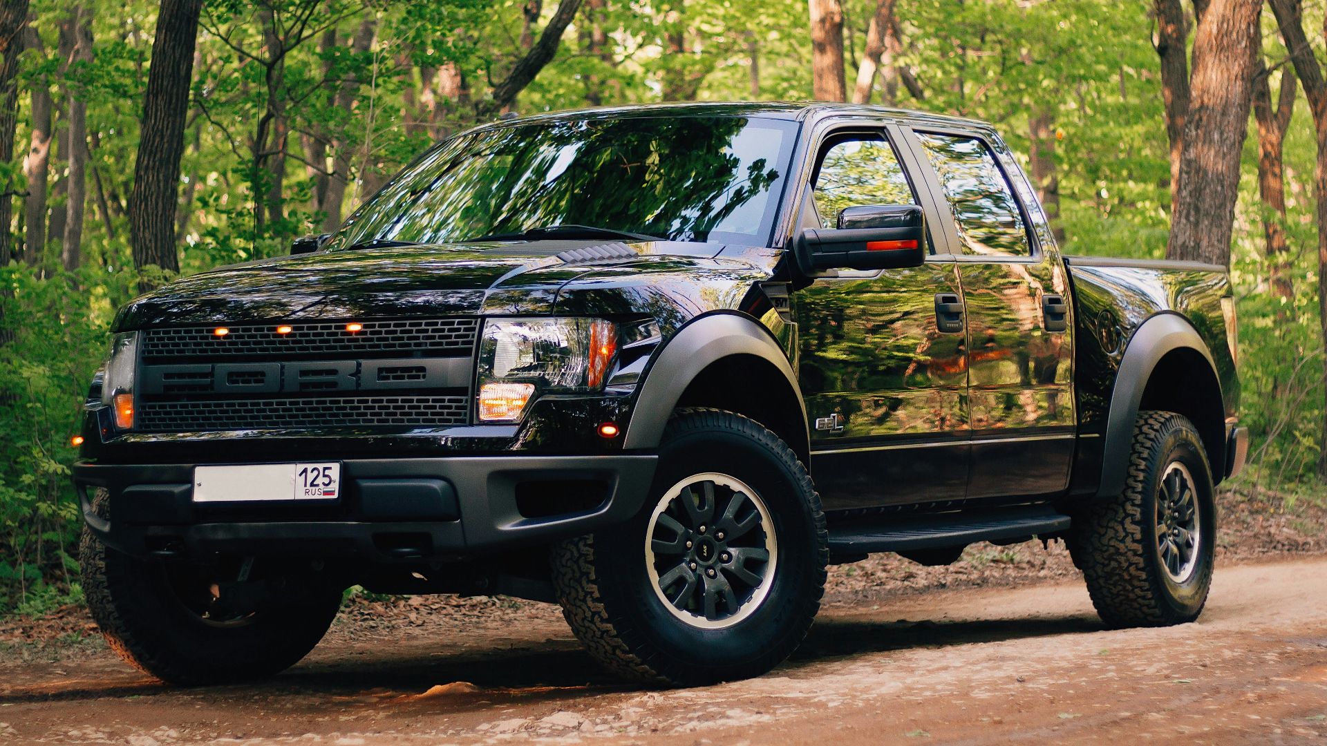 black and yellow chevrolet crew cab pickup truck parked on dirt road during daytime