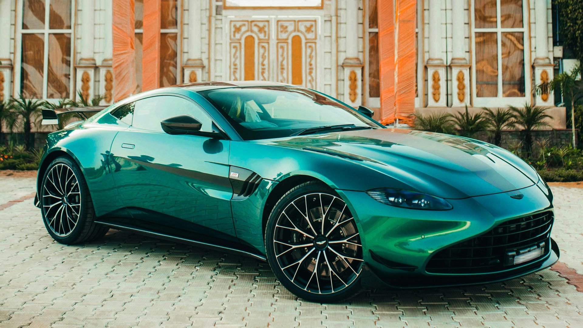 A green sports car parked in front of a building