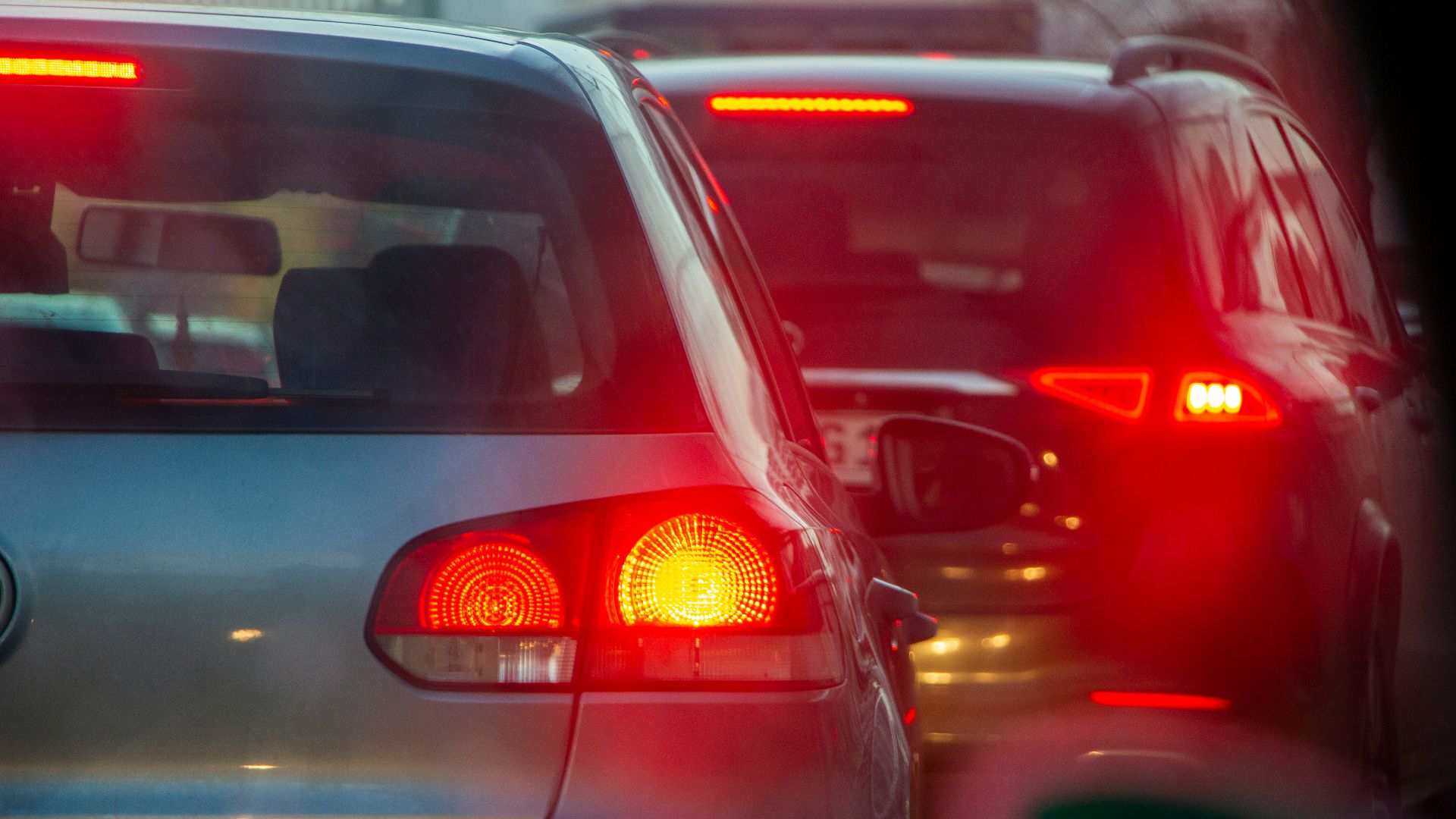 a group of cars driving down a street next to each other