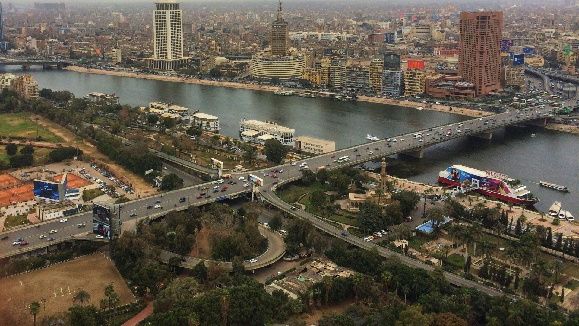ferries along the city river banks near bridge with crossing cars