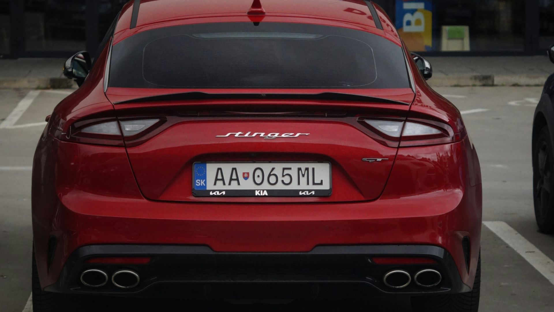 A red car is parked in a parking lot