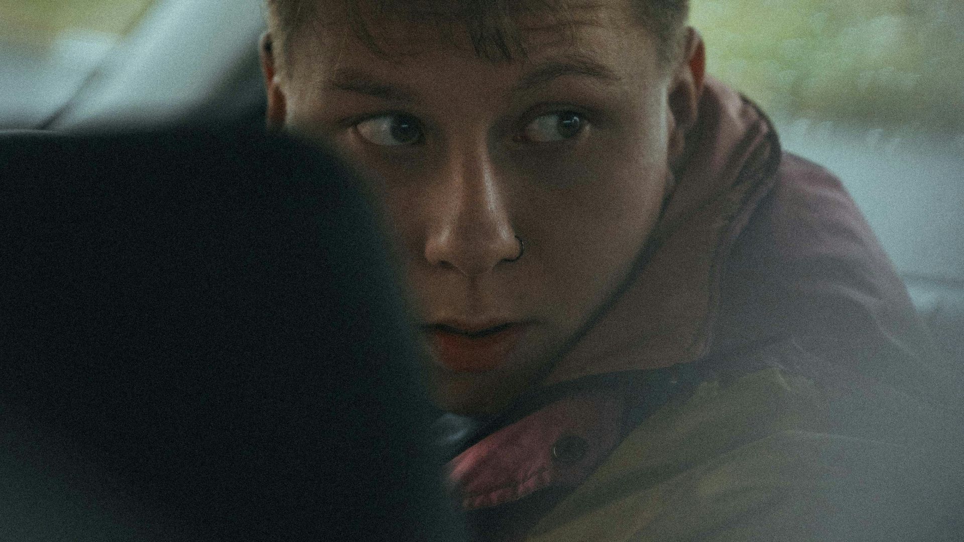man in brown jacket sitting on car seat