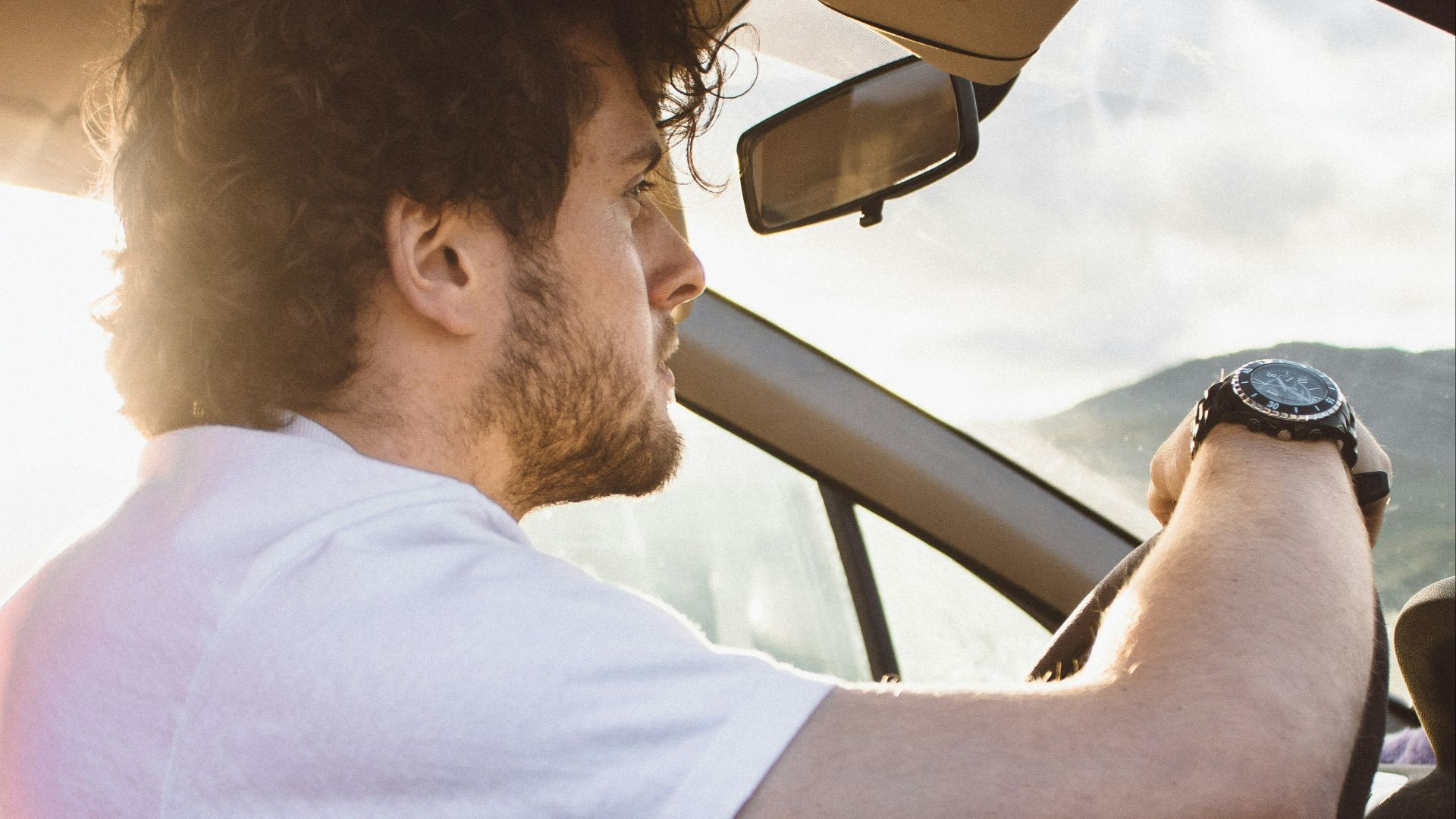 man holding steering wheel
