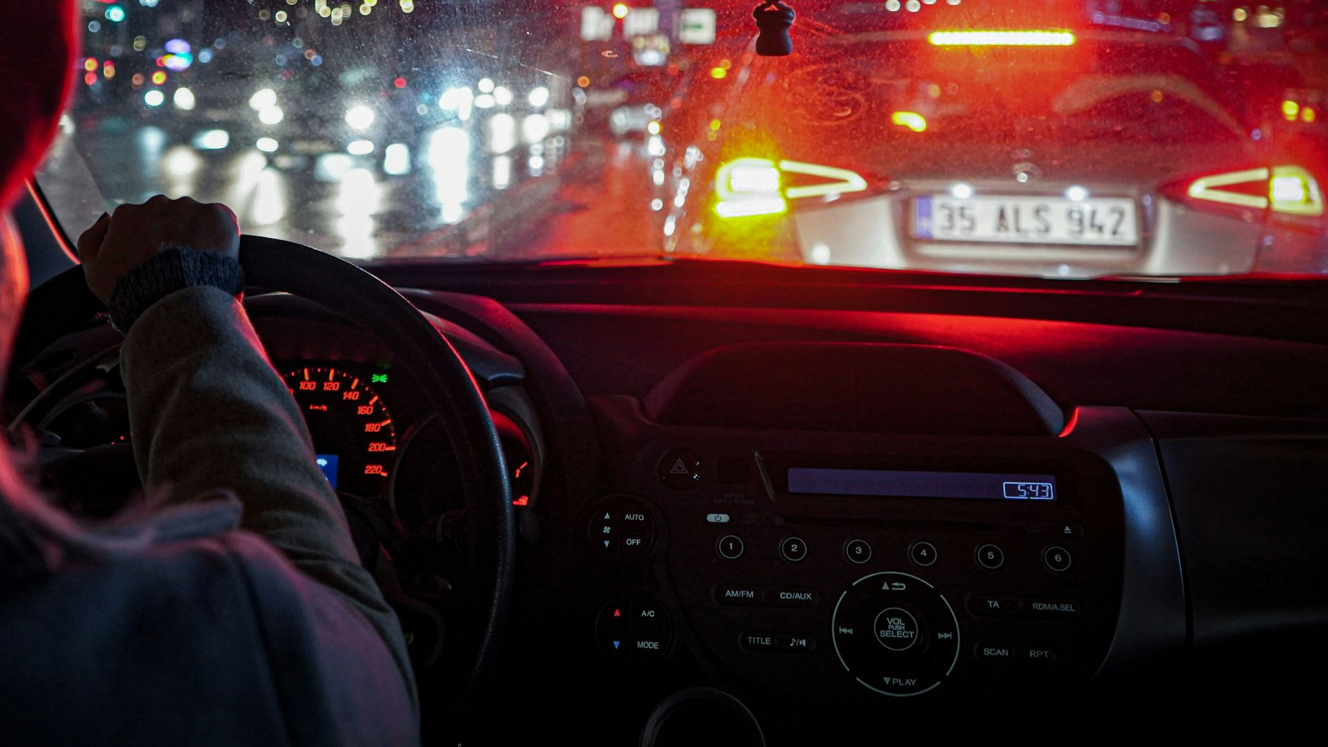 a woman driving a car at night in the rain