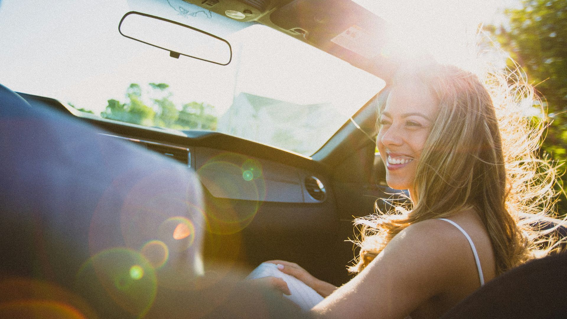 smiling woman sitting inside the vehicle at daytime
