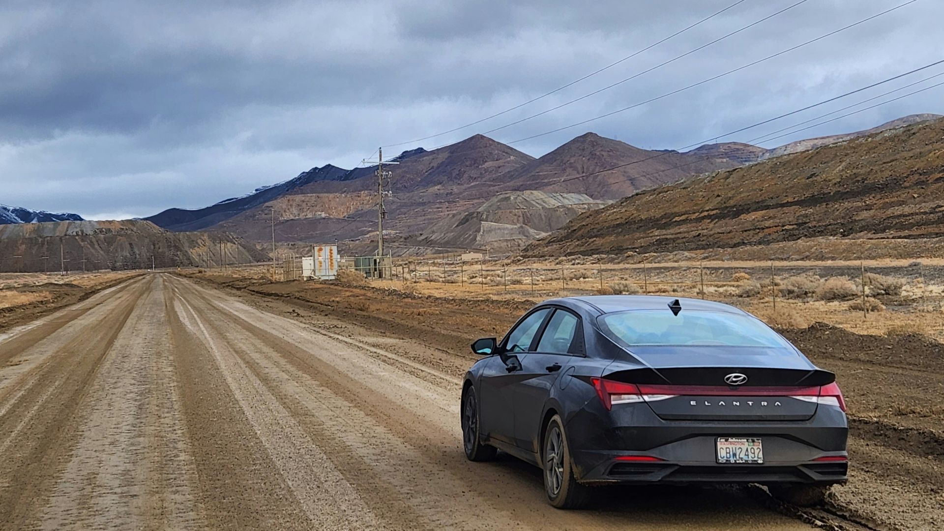 a car parked on a dirt road in the middle of nowhere