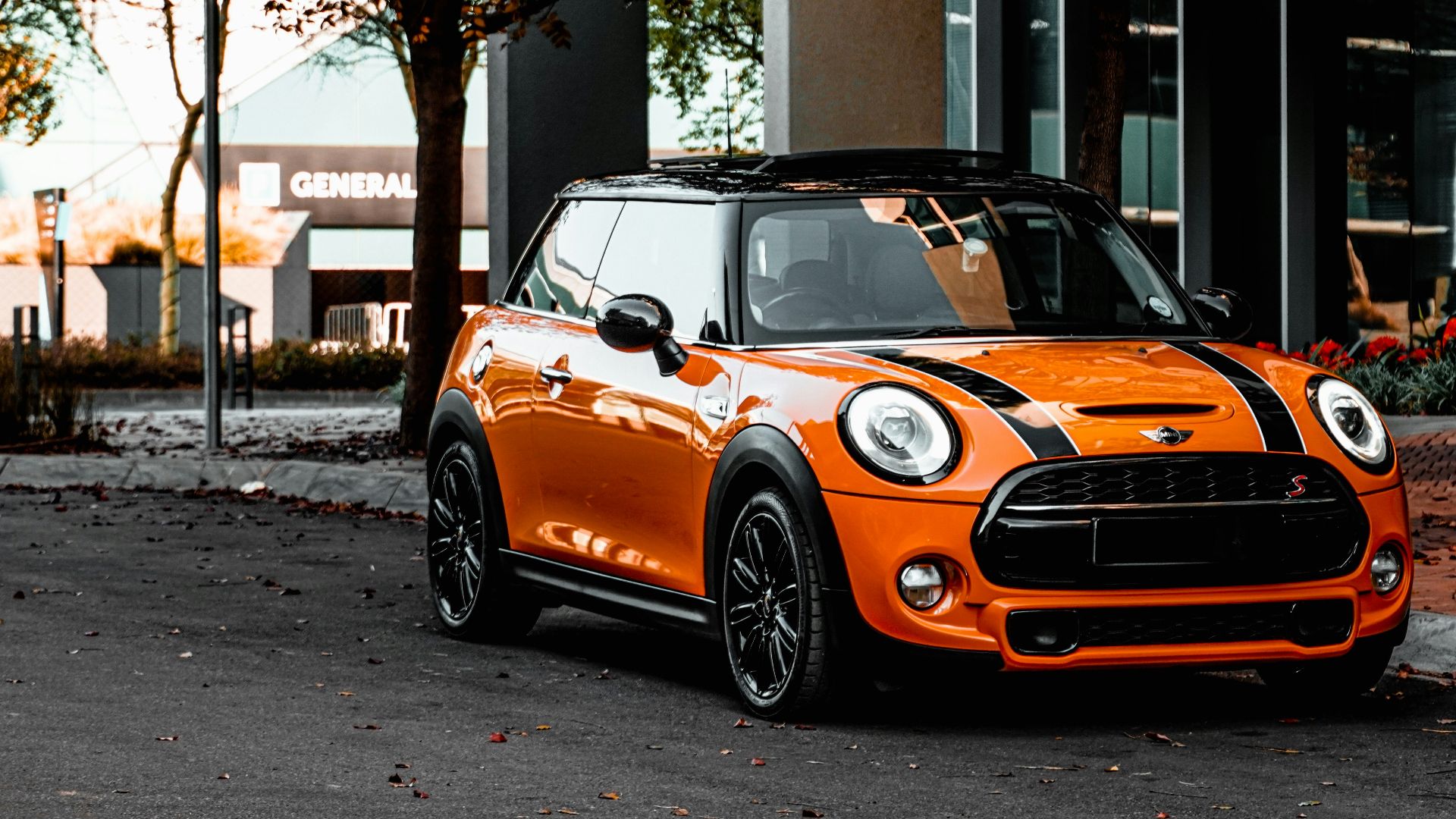 orange bmw m 3 parked on sidewalk during daytime