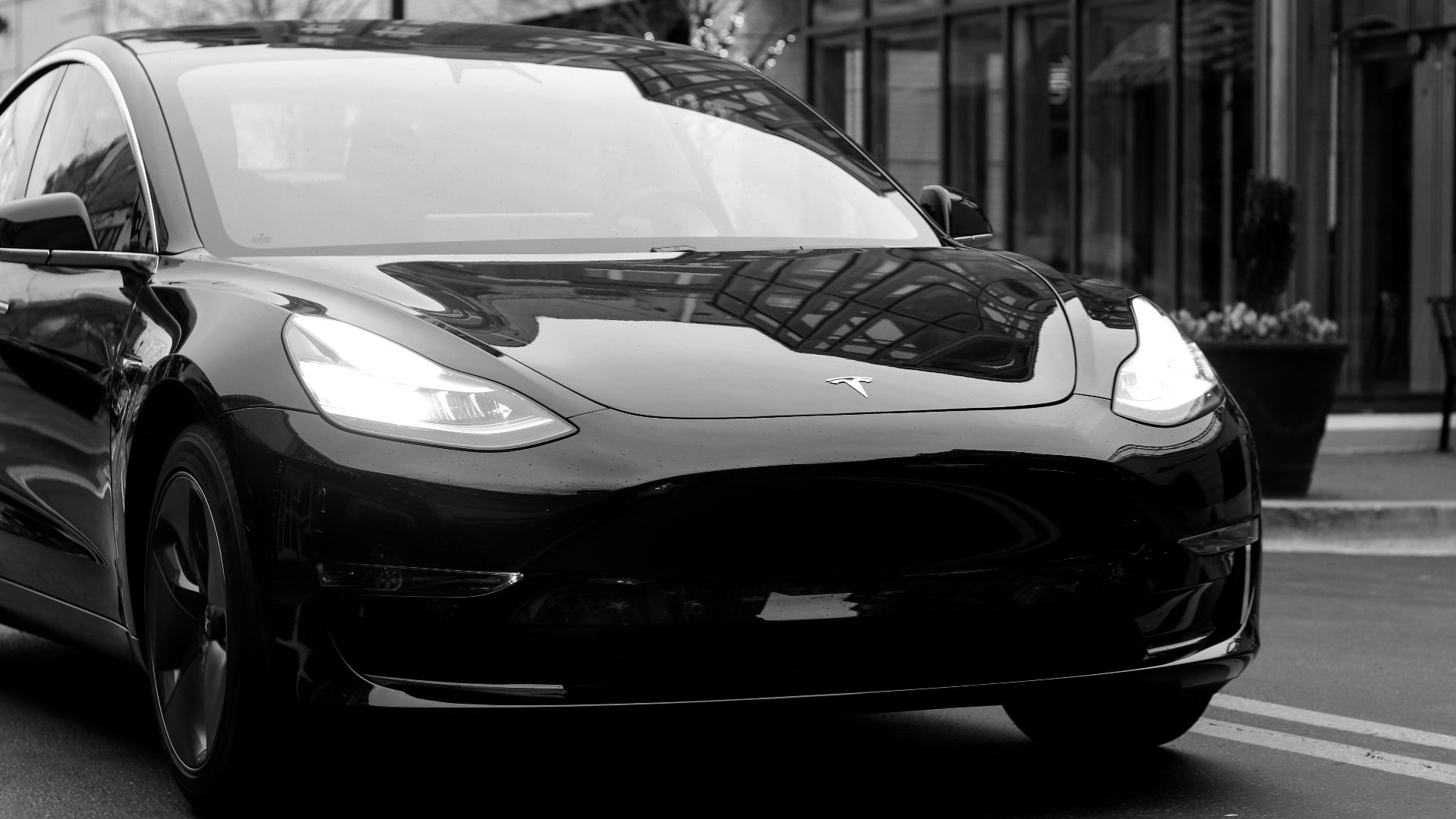 grayscale photography of Grand tourer parking near road