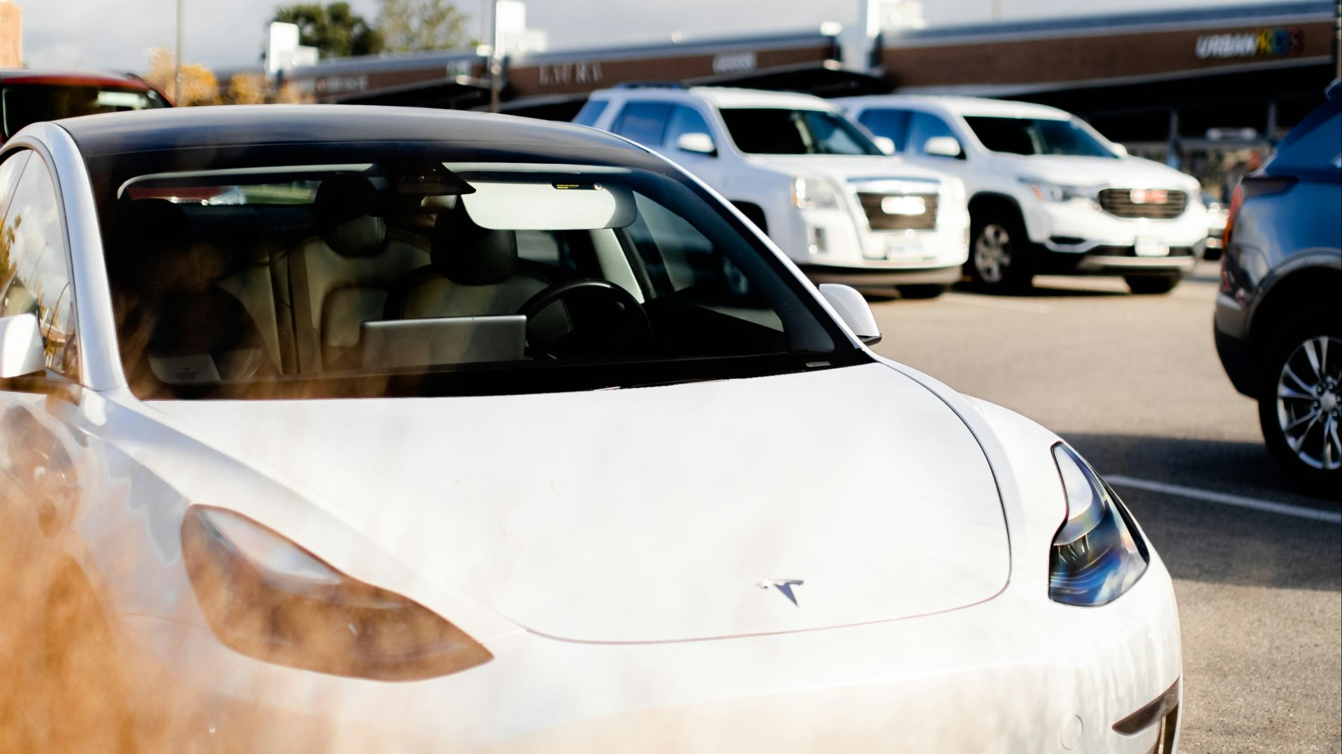 a white tesla parked in a parking lot