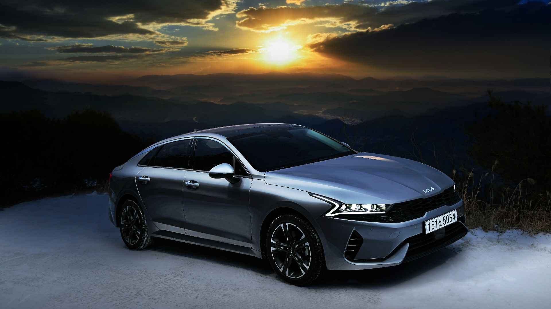 a silver car parked on top of a snow covered slope