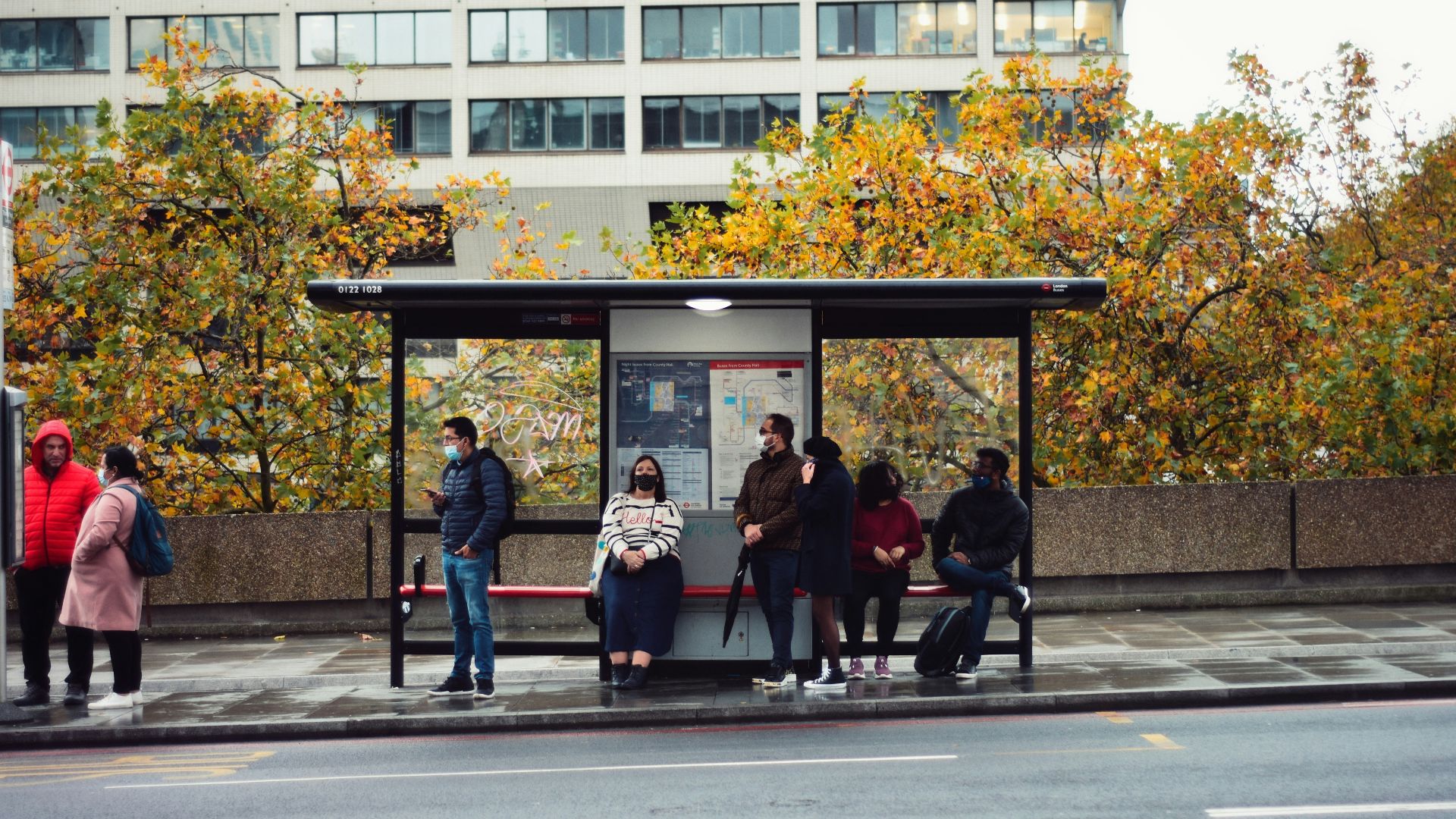 people sitting on bench in front of building during daytime