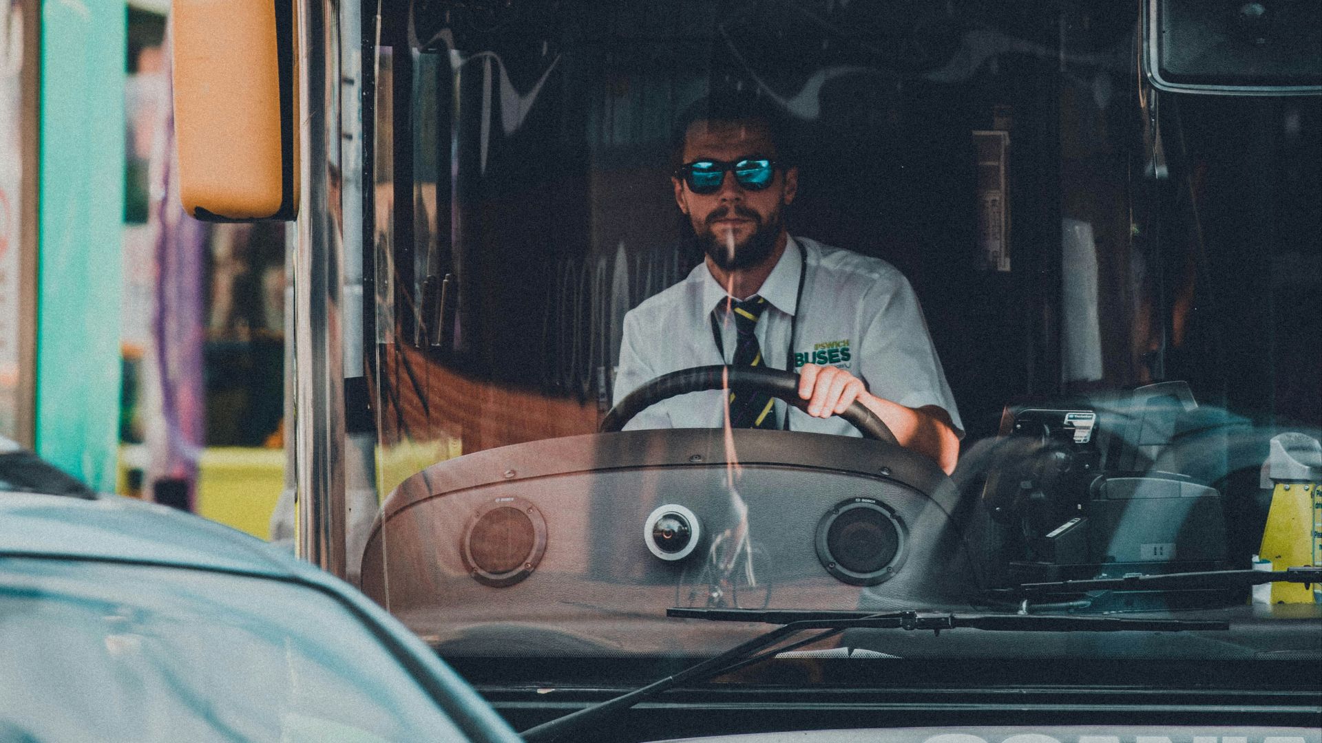 man in black jacket sitting on red bus during night time