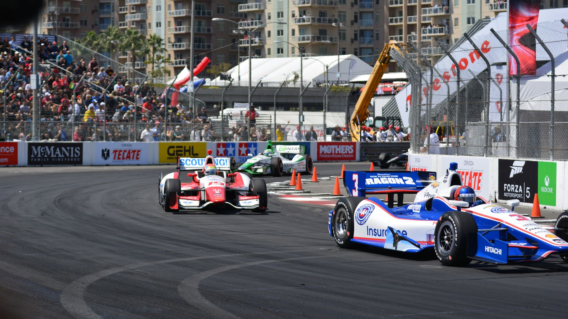 a group of racing cars driving down a race track