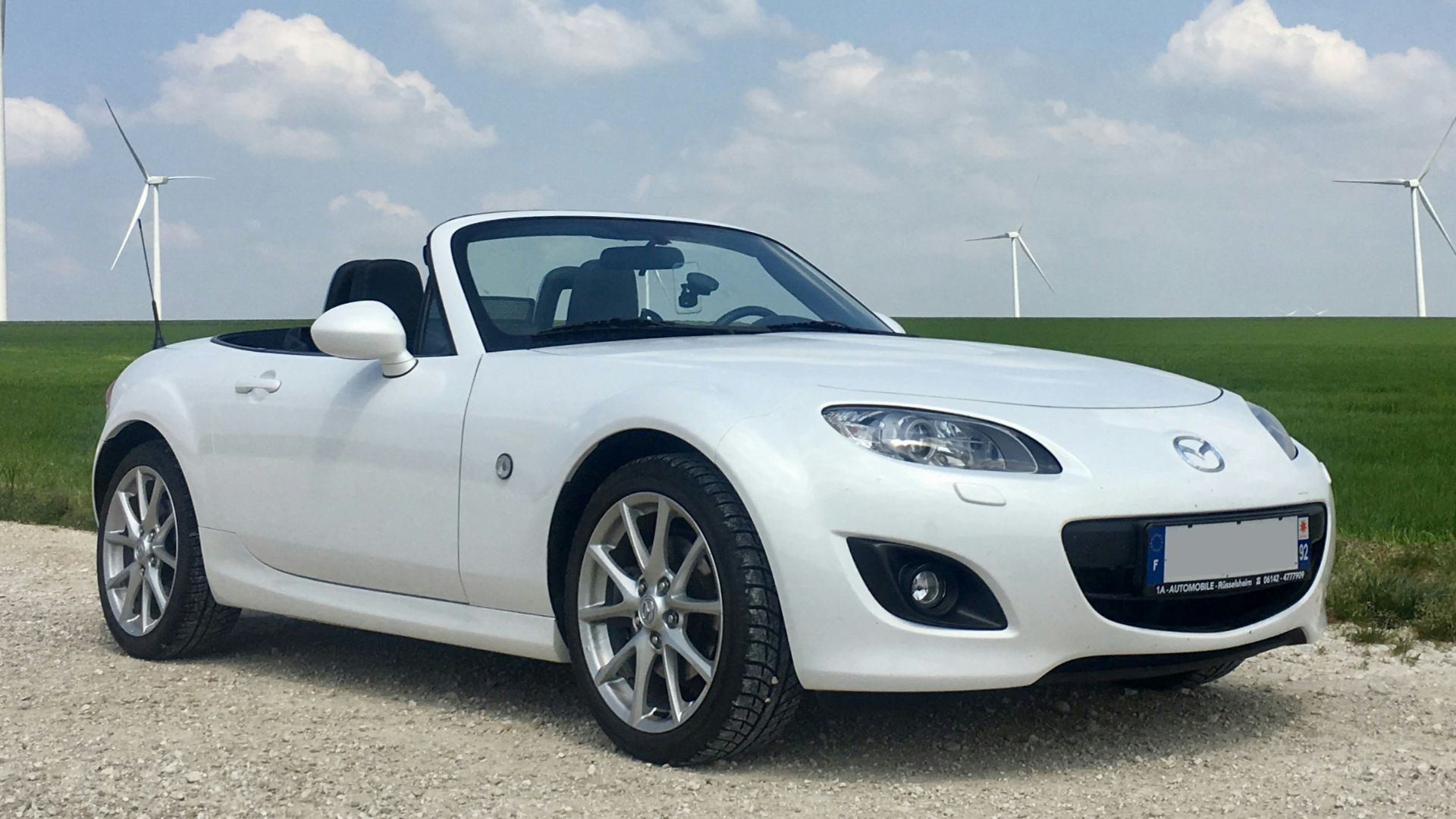 white porsche 911 on green grass field under blue sky during daytime