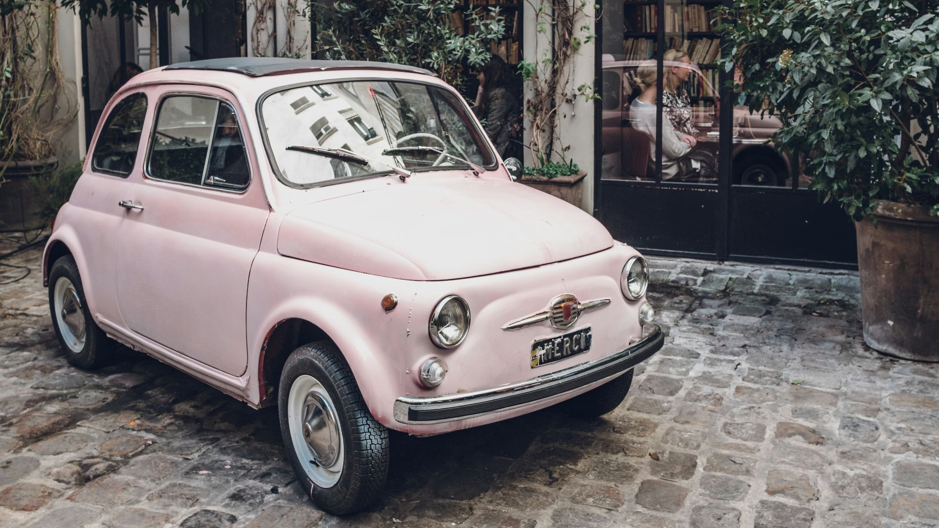 pink FIAT 500 on gray concrete floor