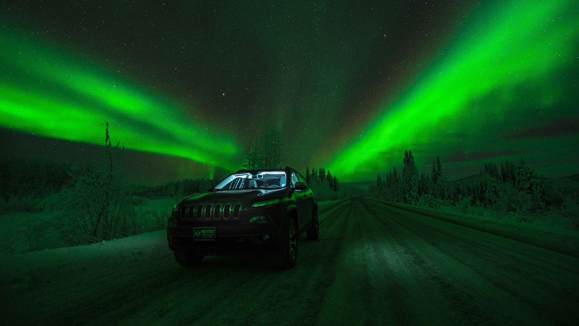 black car on road under Aurora Borealis
