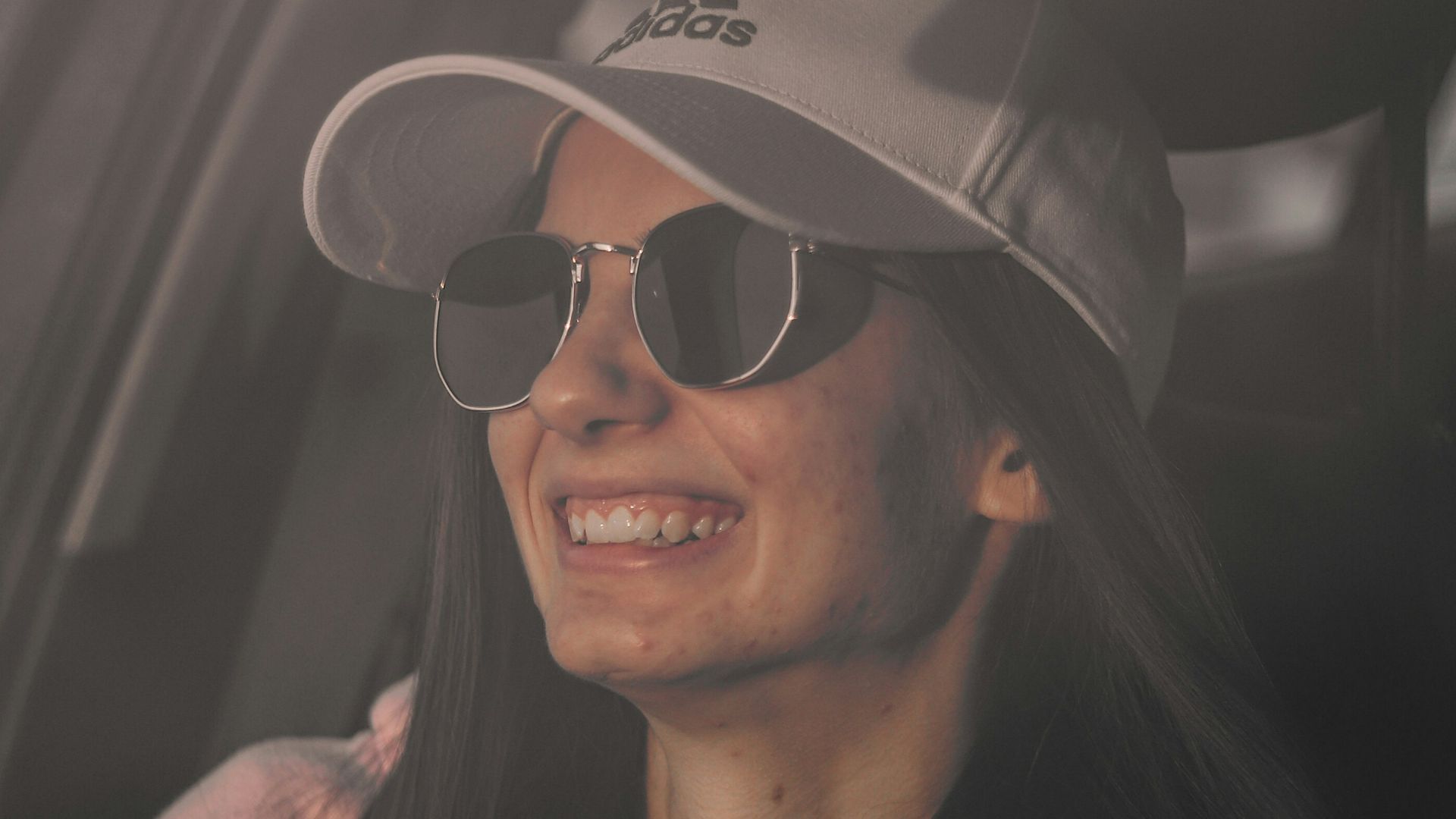 a person wearing a hat and sunglasses