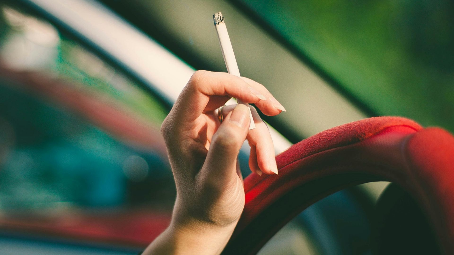 selective focus photography of single cigarette stick on person's hand