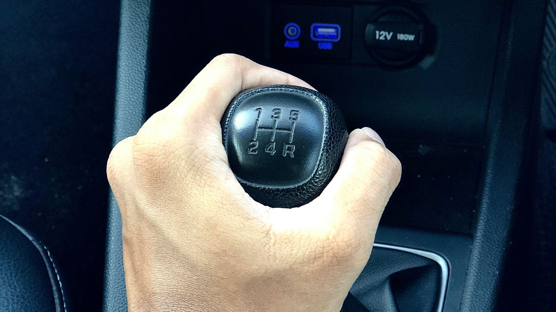 person holding black car gear shift lever
