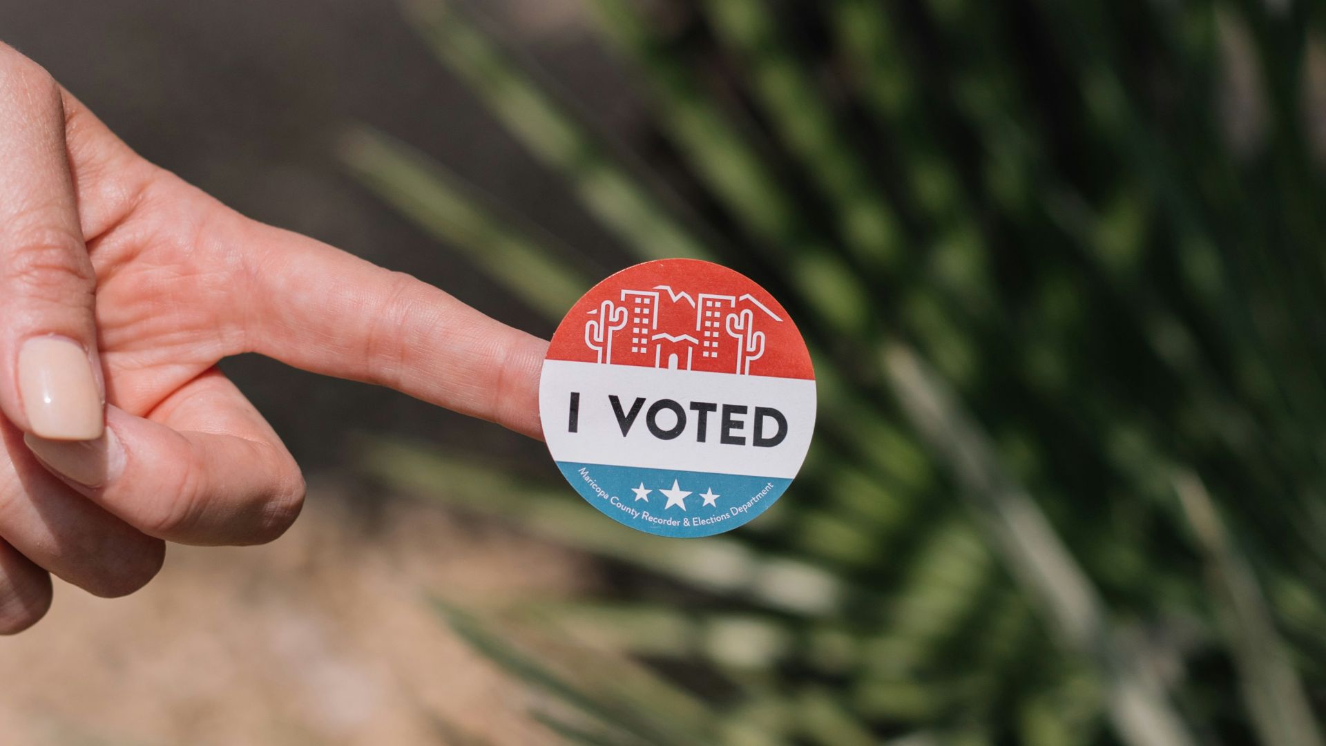 person holding red and white round pin